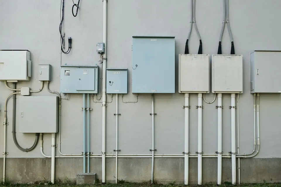 Elektrakasten en buizen aan een gevel